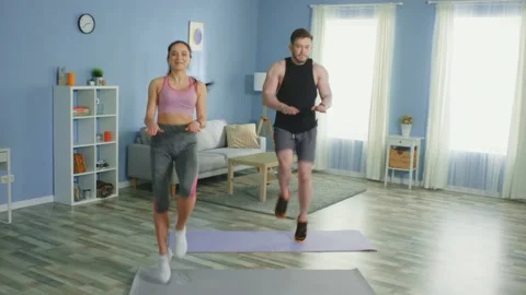 Happy Couple Practice High Knee Jogging at Home Stock Footage 132019231