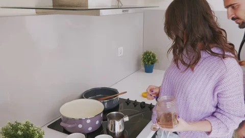 Happy couple preparing cup of coffee in the kitchen Stock Footage 99398250
