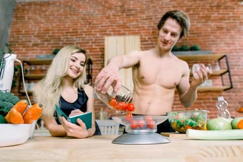 Happy couple preparing dinner in loft kitchen at home. Family cooking healthy Stock Photos