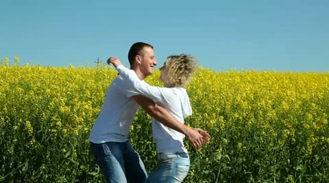 Happy couple on rape field Stock Footage 11115037