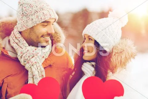 Happy couple with red hearts over winter landscape Stock Photos
