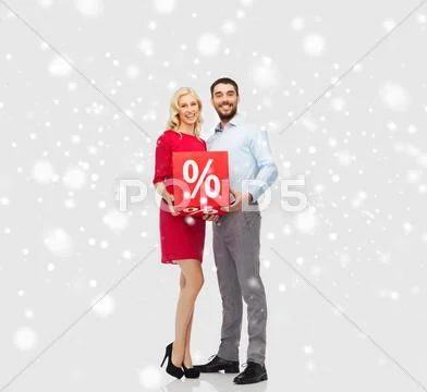 Happy couple with red sale sign over snow Stock Photos