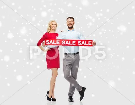 Happy couple with red sale sign over snow Stock Photos