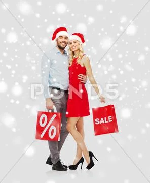 Happy couple with red shopping bags over snow Stock Photos