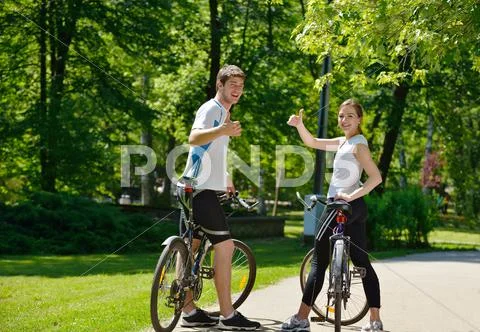 Happy couple riding bicycle outdoors Stock Photos