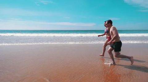 Happy Couple Running on Beach Stock Footage 55449552