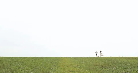 Happy couple running on field Stock Footage 95936210