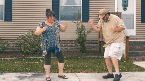 Happy couple saying goodbye, dancing and giving a high five in front of a house Stock Footage 87793330