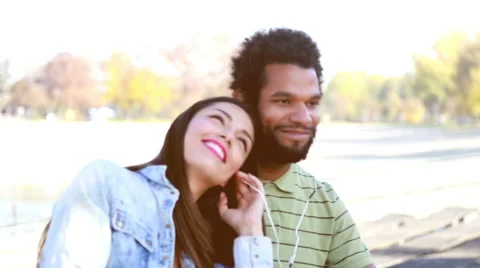 Happy couple with shared earphones listening to music and enjoying Stock Footage 59555097