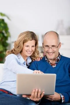 Happy couple sharing a laptop computer Stock Photos