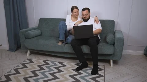 Happy couple shopping online using laptop and credit card on sofa Video stock 320501683