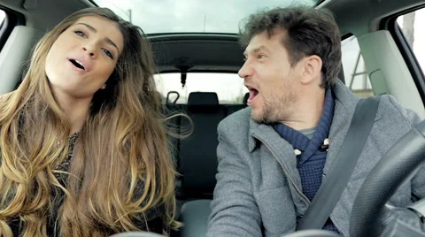 Happy couple singing and dancing while driving car looking camera slow motion Stock Footage 61932125