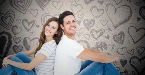Happy couple sitting back to back Stock Photos