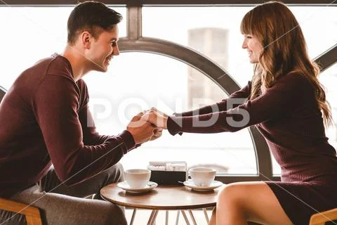 The happy couple sitting at the restaurant table near the window Stock Photos