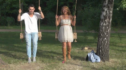 Happy couple sitting in a swing 스톡 동영상 23747495