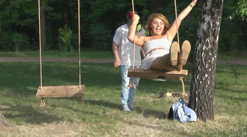 Happy couple sitting in a swing 스톡 동영상 23747867