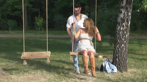 Happy couple sitting in a swing 스톡 동영상 23748254
