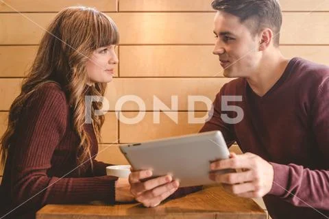 The happy couple sitting with a tablet at the restaurant table Stock Photos