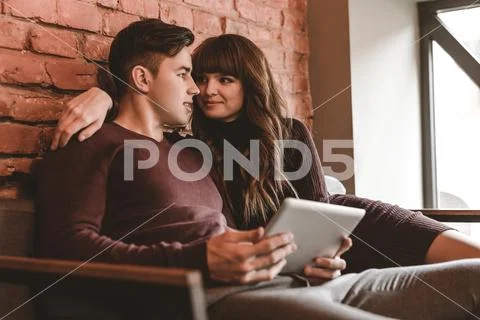 The happy couple sitting with a tablet in the restaurant Stock Photos