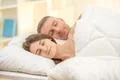 The happy couple sleeping on the bed Photo