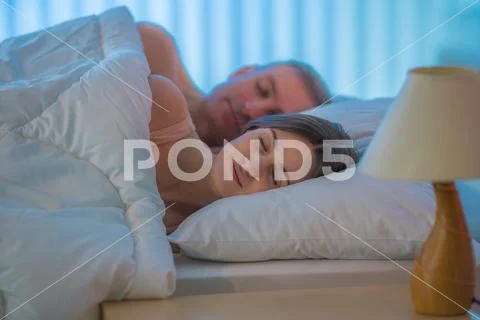 The happy couple sleeping on the bed Stock Photos