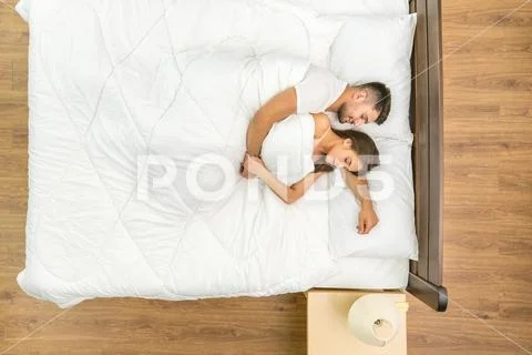 The happy couple sleeping on the bed. View from above Stock Photos