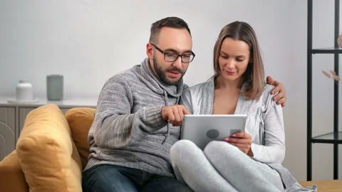Happy couple smiling talking use tablet together relaxing comfy couch. 4k Dragon Stock Footage 149346556