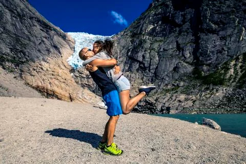 Happy couple standing in front of the Briksdaalsbreen glacier, Norway. Stock Photos
