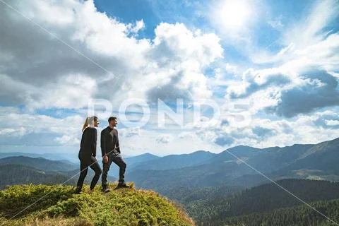 The happy couple standing on the mountain with a picturesque cloudscape Stock Photos