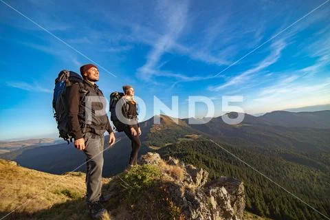 The happy couple standing on the sunny mountain Stock Photos