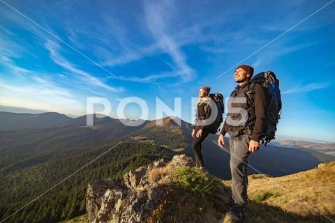 The happy couple standing on the sunny mountain Stock Photos
