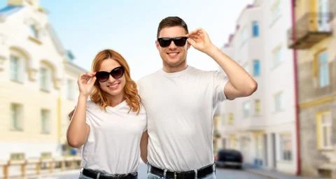 Happy couple in t-shirts and sunglasses in city Stock Photos