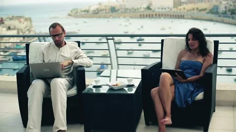 Happy couple with tablet computer and laptop on the terrace Stock Footage 17832570