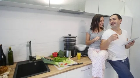 Happy couple with tablet computer in kitchen at home Stock Footage 83556682