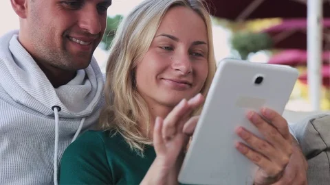 Happy couple with tablet computer sitting in cafe. Stock-Footage 81543499