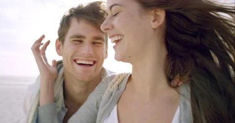 Happy couple taking selfie on beach at sunset using phone smiling and spinning Stock Footage