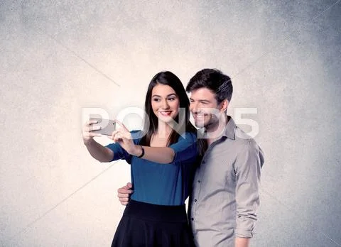 Happy couple taking selfie with clear wall Stock Photos