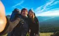 The happy couple taking a selfie on the mountain background Photo