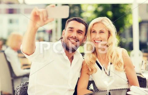 Happy couple taking selfie with smatphone at cafe Stock Photos