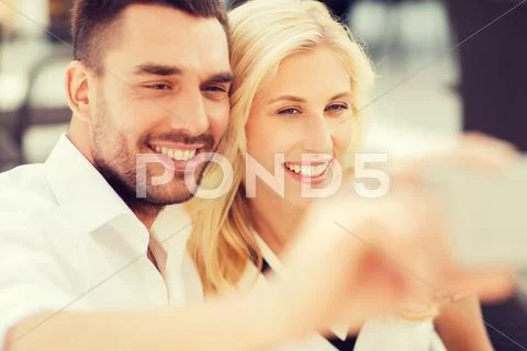 Happy couple taking selfie with smatphone outdoors Stock Photos