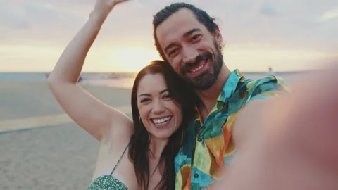 Happy couple taking selfie while standing on the beach Stock Footage 227142229