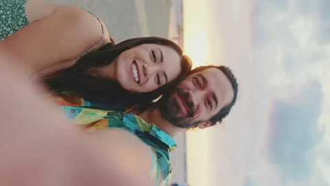 Happy couple taking selfie while standing on the beach Stockbeeldmateriaal 227142267