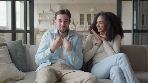 Happy Couple Talking On Sofa While Woman Reacts To Good News At Home 스톡 동영상 331788908