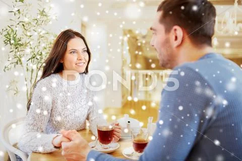 Happy couple with tea holding hands at restaurant Stock Photos