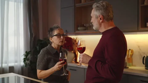 Happy couple in their 50s drinking wine and talking, enjoying weekend together Stock Footage 340920208