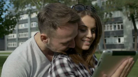 Happy couple using digital tablet in park. Stock Footage 54676592
