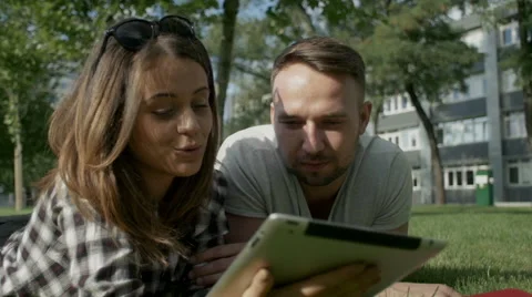 Happy couple using digital tablet in park. Stock Footage 54677619