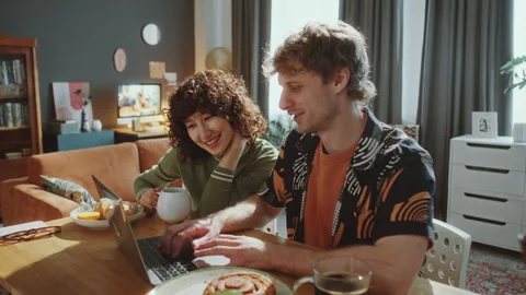 Happy Couple Using Laptop and Talking over Breakfast at Home Stock Footage 306457165