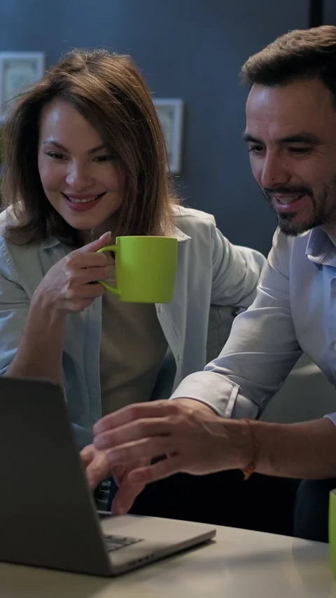 Happy couple using laptop computer browsing through websites, planning vacation Stock Footage 297892552