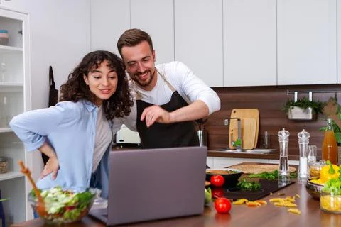 Happy couple using laptop computer preparing healthy food diet vegetable sala Foto stock